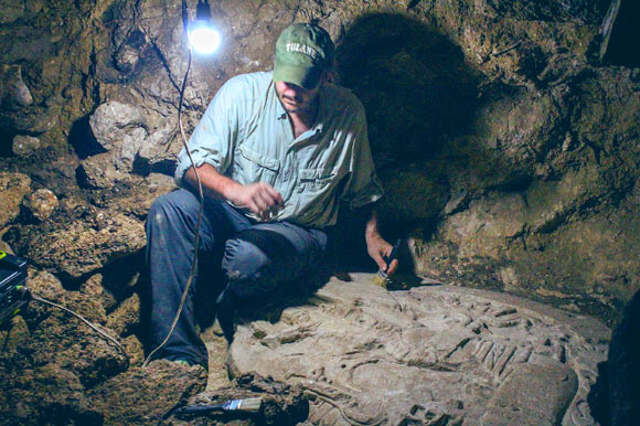 考古学家Marcello Canuto博士坐在他和他的同事在危地马拉北部的丛林中发现的古代玛雅祭坛旁边。 图片来源：危地马拉城国家考古和民族学博物馆/拉科罗纳地区考古项目。